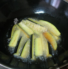 金针茄子煲,锅中放入适量的色拉油,开大火,油七八成热时,放入茄子