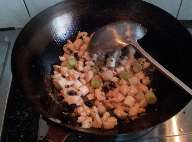 宫保鸡丁,倒入鸡肉煸炒至颜色变白加入葱白继续煸炒，倒入调好的调味汁，加适量湿淀粉汁勾一个薄欠，加入花生米，翻炒均匀即可出锅