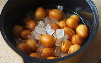 蜂蜜黄皮茶饮,放入冰糖,倒入没过黄皮的水