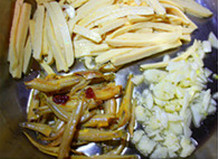 客家小炒,中火加热炒锅中的油至3成热,放入蒜末、豆干条和<a style='color:red;display:inline-block;' href='/shicai/ 7576'>小鱼干</a>煸炒,豆干表面微微起泡,捞出控干备用