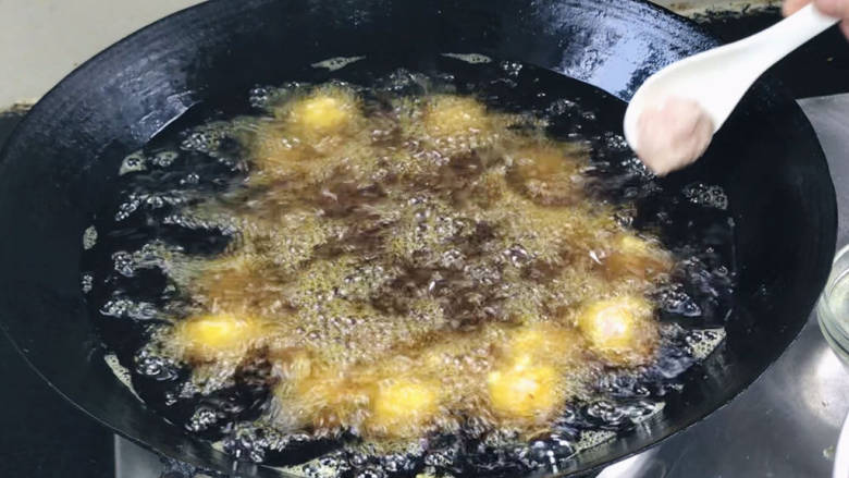 手工肉丸,放七成热的油锅中,挤丸子的时候将火打至中火,一次挤一锅丸子,用锅铲背部轻轻推搬均匀