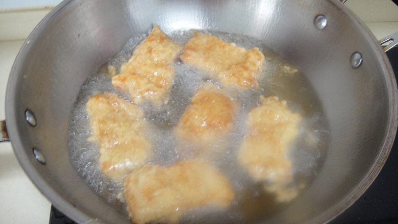 酥炸鱼排,等油温升高再下入煎炸至酥脆,颜色金黄捞起