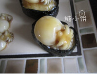 墨鱼仔寿司,上面摆上墨鱼仔,再淋上一些拌墨鱼仔的酱汁,完成
