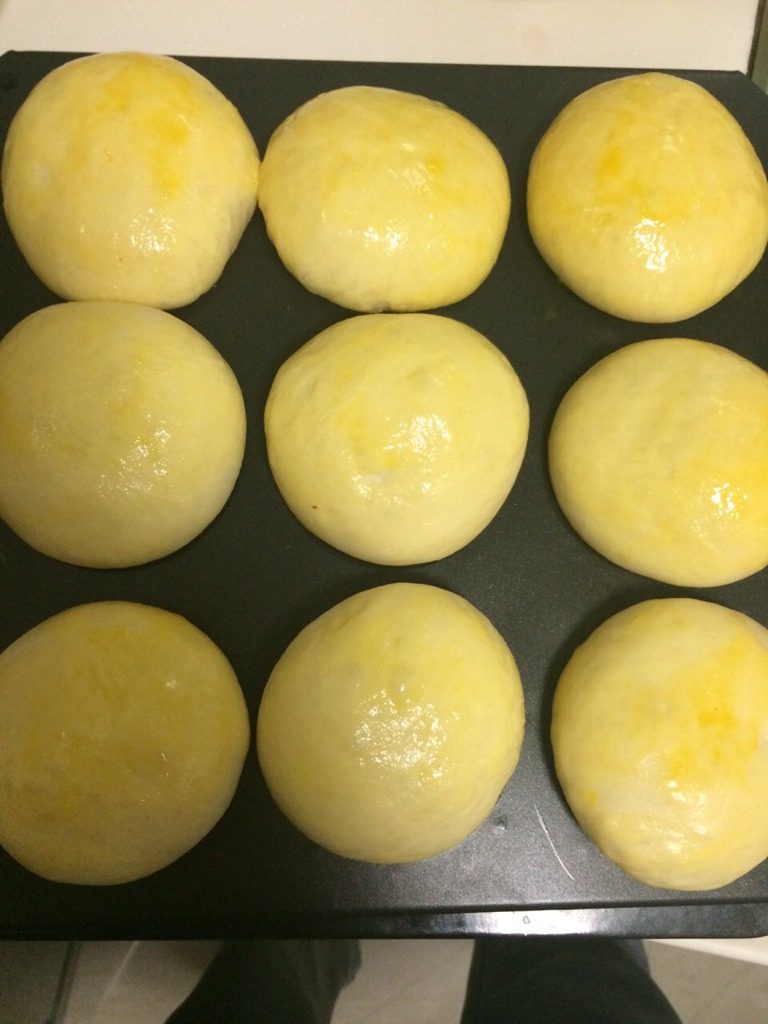 叉烧餐包,如图将9连模放在烤箱中格，下格摆放一碗开水，烤箱温度调至40度，启动发酵程序开始2发，时间为40--50分钟。2发至2.5倍大，取出来用羊毛刷在表面涂上蛋液；