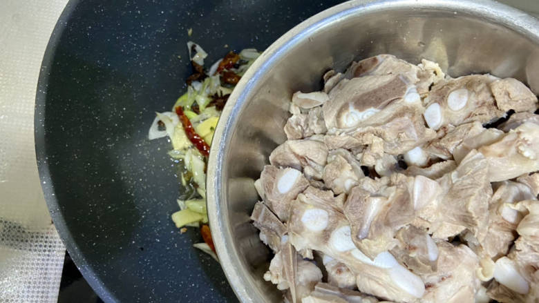 排骨土豆炖豆角,加入沥水的排骨,中火翻炒到排骨表面微黄