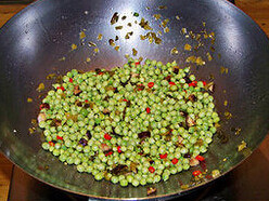 小炒豌豆,坐锅起油，下酸菜、香菇丁和小米辣圈圈爆香，下豌豆粒，加盐炒至豌豆表面即将出现爆裂花纹