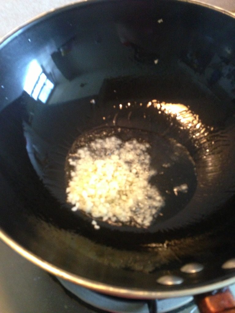 蒜茸粉丝蒸扇贝,蒜切末。热锅放油,热至六分,将蒜末爆香。炒至七分熟。