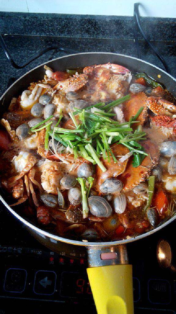 海鲜锅,锅入油,下干香料油爆,再下姜,蒜(去皮整粒),小红椒爆炒,放西红柿加盐,糖,生抽提味,少量老抽上色,加清水烧开。另:海鲜除壳类外全焯水去腥,冲洗干净后倒入香料汤锅中煮沸入味,最后放葱,香菜去腥增香。