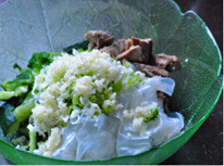 剔骨肉拍黄瓜,将排骨肉、黄瓜段、粉皮、葱姜蒜末、香菜末和青椒末统统放进大碗