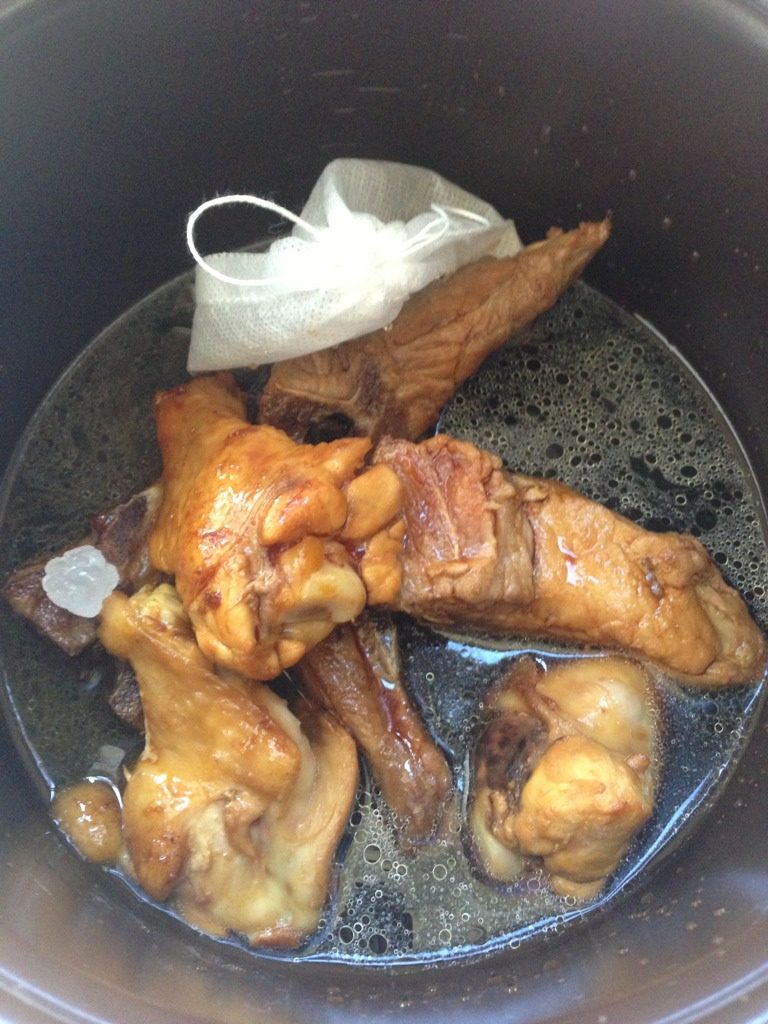 用电饭煲炖肉勾鸡,将翻炒后的肉和酱汁一起放进电饭煲内胆，择出去蒜片，把料袋放进去，加<a style='color:red;display:inline-block;' href='/shicai/ 718'>料酒</a>、三勺<a style='color:red;display:inline-block;' href='/shicai/ 762'>老抽</a>、<a style='color:red;display:inline-block;' href='/shicai/ 866'>冰糖</a>适量，<a style='color:red;display:inline-block;' href='/shicai/ 718'>料酒</a>的量以肉的二分之一高度为宜