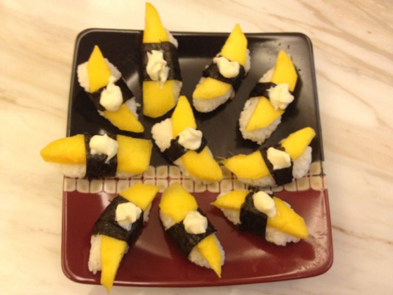 家庭紫菜寿司卷,先做芒果翻卷、可以直接用手把饭团捏成行然后放上芒果片用刚剪好的紫菜条绑好、然后放点沙拉点缀下即可。