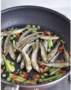 香辣火焙鱼,倒入小鱼，小火翻炒。调入少许的精盐，洒上<a style='color:red;display:inline-block;' href='/shicai/ 131'>香菜</a>段，翻炒均匀即可