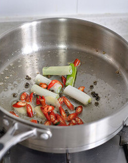 干煸鸡,把鸡肉盛出,锅里留底油,放入尖椒段葱段小火煸炒至葱段微黄