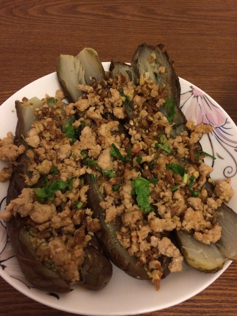 肉末蒜蓉茄子,煮好的茄子晾干,摆盘,用刀切开并摊开,最后淋上酱料,用葱花和香菜做点缀。