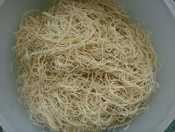 卤面,把蒸过15分钟的面条从蒸锅里取出放在一个大盆子里用筷子抖开弄散
