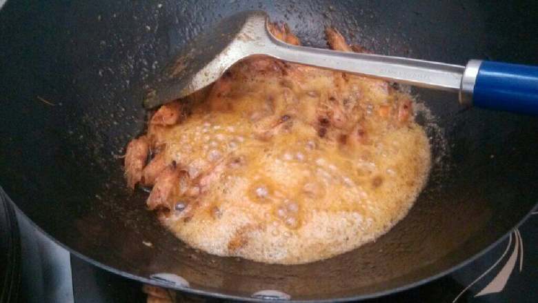 香酥虾头及虾油,慢慢的虾头里的虾油会被熬出来,并出现很多泡沫,用锅铲轻轻按压虾头,使虾油充分的析出