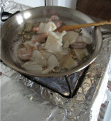 酸奶油海鲜冷面,蒜切蒜米，放油锅，炒香，把鱼虾滗干，倒入锅内