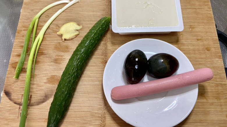 皮蛋豆腐汤,皮蛋剥壳洗净,豆腐火腿肠去除包装,黄瓜搓洗干净,小葱择好洗净,姜搓洗干净