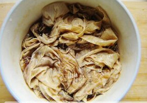素烧鹅,将浸润后的豆腐皮边筋撕下后,入酱汁中浸泡一会