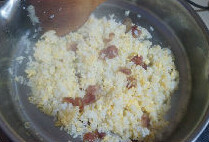鸡蛋腊肠炒饭,一分钟后，加入鸡蛋液翻炒至米饭表面干爽