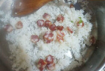 鸡蛋腊肠炒饭,热锅下油倒入米饭翻炒散开来，倒入切好的腊肠丁