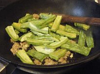 干煸苦瓜,油锅爆香大蒜粒，加入猪肉末炒散，加料酒，下苦瓜和辣椒继续煸炒