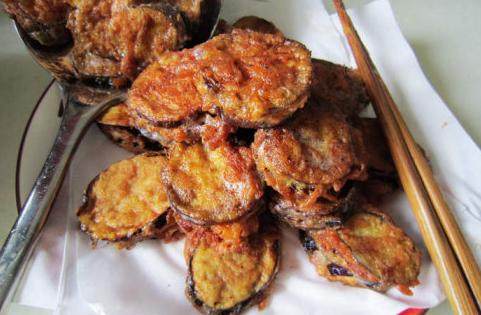 糖醋茄夹 ,油锅7程热时，放入裹好糊的茄夹，炸制两面金黄。捞出沥油备用