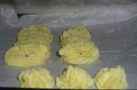 焖酥土豆,放入装有裱花嘴的裱花袋,在铺了油纸的烤盘上挤出自己喜欢的花形