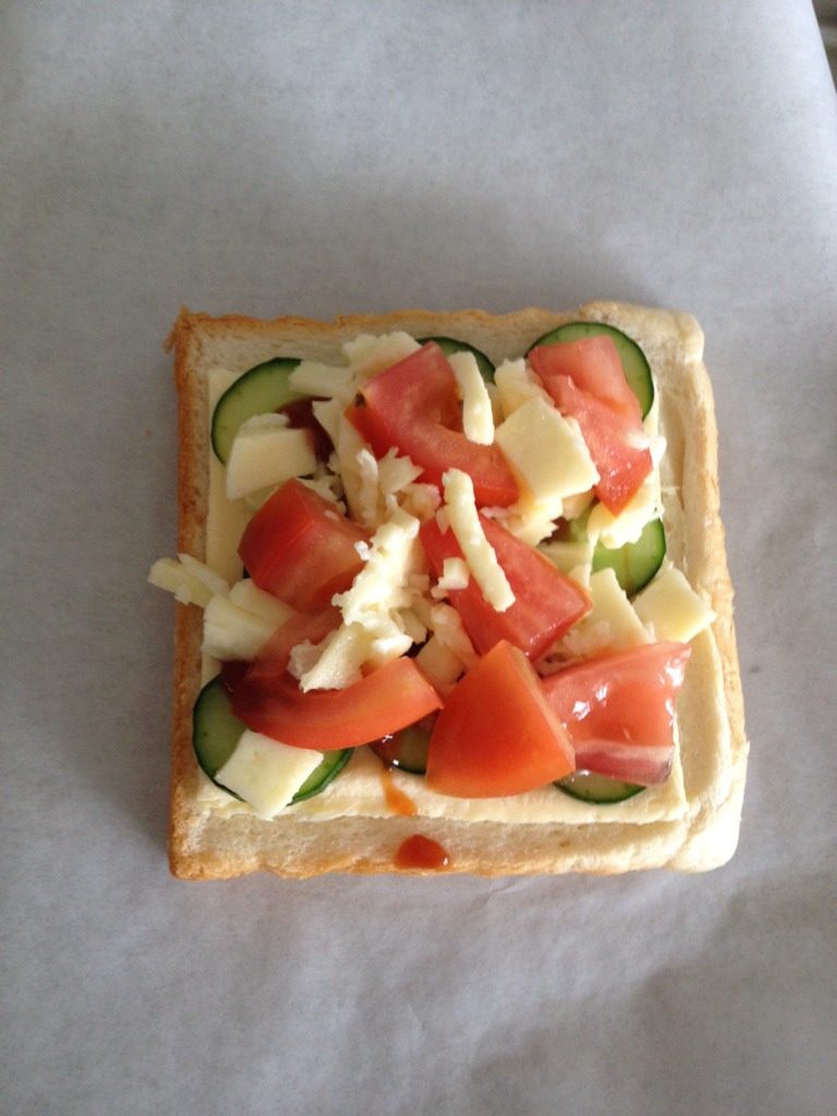 用吐司做披萨,吐司片涂上<a style='color:red;display:inline-block;' href='/shicai/ 699'>番茄酱</a>，放上<a style='color:red;display:inline-block;' href='/shicai/ 935'>芝士</a>，番茄，黄瓜片，最后铺上马苏里拉。