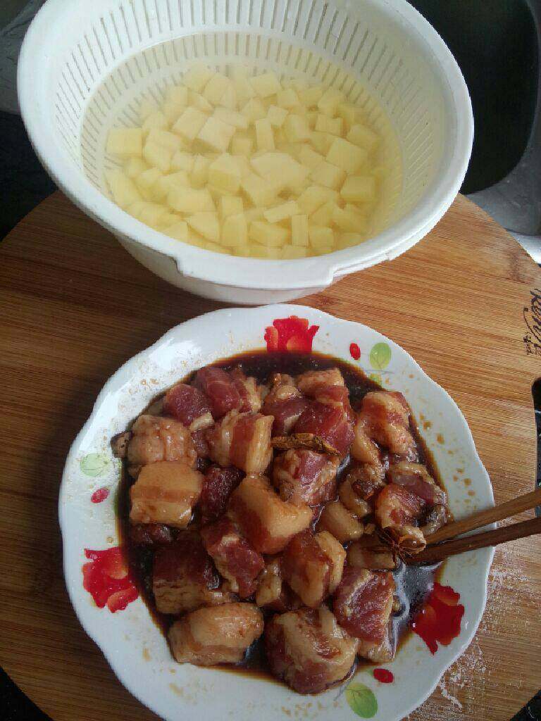 土豆炖五花肉,准备好食材：土豆切块入水，五花肉切块加上述备料腌制十分钟
