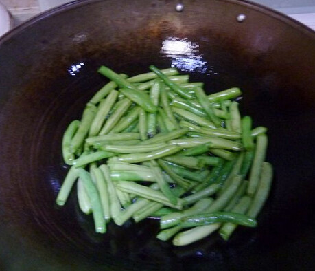 干煸榄菜四季豆,四季豆放入油锅，大火炸4分钟，捞出沥油