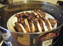 芋头扣肉 ,放入蒸锅大火蒸60分钟,至肉软烂,将整碗扣肉小心倒扣在盘子中即可
