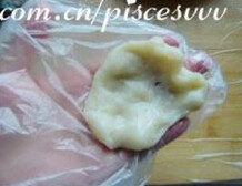 蜜红豆糯米糍,取一小块糯米团,揉圆后按扁,裹入蜜豆馅后包起,揉圆