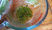 龙井虾仁,茶叶用约50ml开水冲泡约1分钟,滤出约15ml茶水,并取几片茶叶放在一起备用
