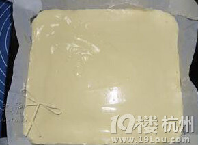 蓝莓椰丝蛋糕卷,将拌好的面糊倒入烤好花纹的烤盘,抹平拿起烤盘,用另一只手轻拍底部,拍出大气泡