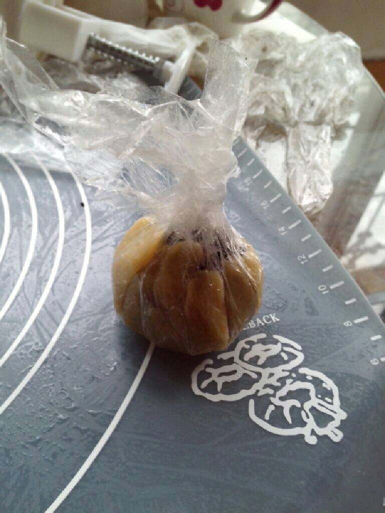 五仁月饼,把保鲜膜提起,捏紧,两面慢慢向上推均匀,直到把馅完全包住。