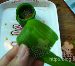 小葱拌豆腐,取一片比较宽的葱叶，从中间分开，然后卷成圆柱形