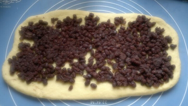 红豆吐司,将松弛好的面团稍微滚圆放气，用擀面棍擀成牛舌状，铺上红豆馅