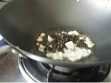 豆豉鲮鱼炒茄子,锅里放入豆豉鲮鱼罐头里面的油，烧热，爆香大蒜粒，倒入豆豉炒香