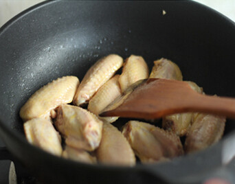 可乐姜汁鸡翅,锅内倒油，烧热，倒入鸡翅煎至鸡翅金黄