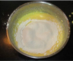 牛奶轻乳酪蛋糕,低筋面粉30克和粟粉30克混合均匀过筛进搅好的蛋黄液里,搅匀至无颗粒状