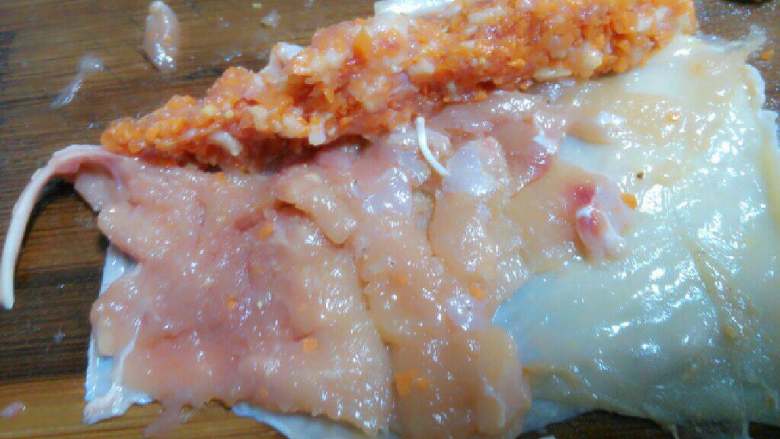黄金鸡肉卷,把肉馅横向放鸡腿肉上,卷成一根条一趟。