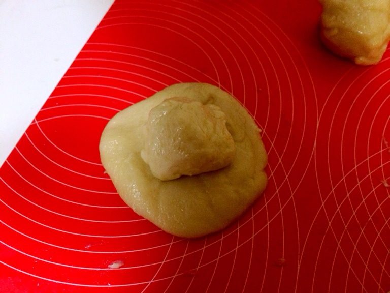 小当家老婆饼,把油皮按扁包油酥,包好再次压平,用擀面杖擀长,卷起,再次压平。重复三次本步动作