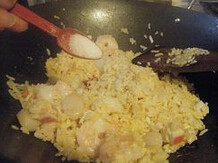 鲍汁海鲜炒饭,加入虾仁,带子和蟹棒,再炒均匀,调入鲍汁,盐炒出香味,洒料酒再炒均匀