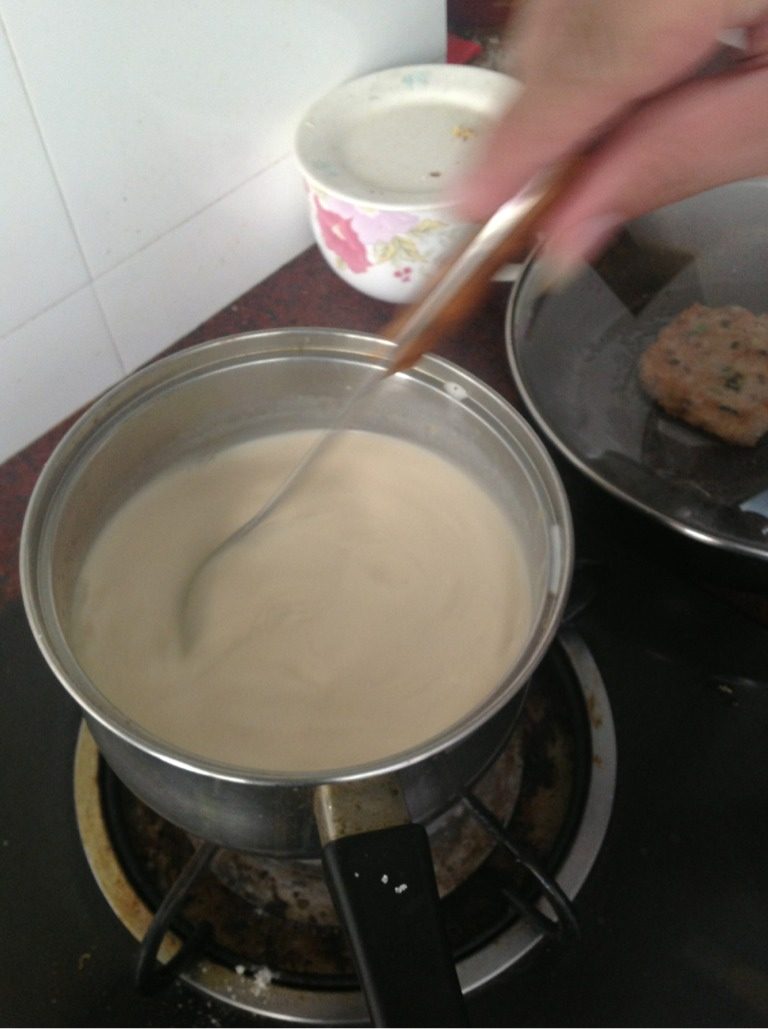 桂花椰汁千层果冻,将两碗半水大火煮开加入适量砂糖,一边煮一边倒入250g<a style='color:red;display:inline-block;' href='/shicai/ 635'>椰浆</a>和150g三花淡奶。煮开后调小火,就一边倒入鱼胶粉一边搅拌,直到鱼胶粉完全溶化。