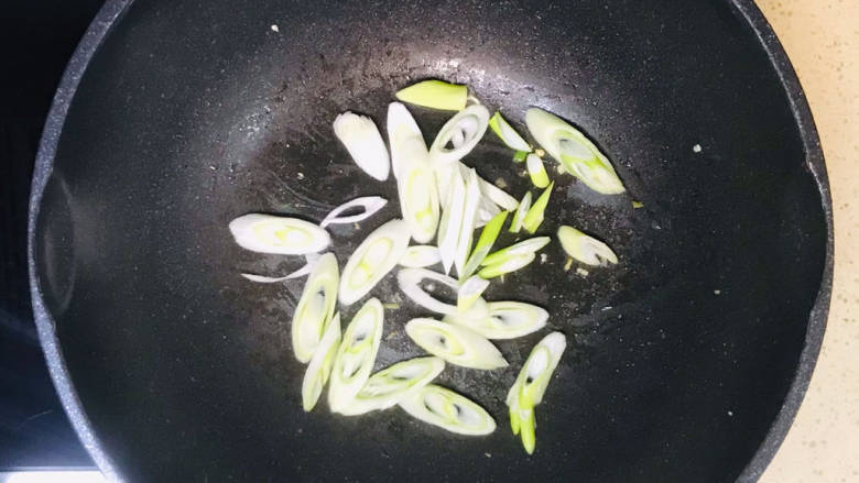 猪肉烧板栗,起油锅,加入大葱,煸炒出葱香