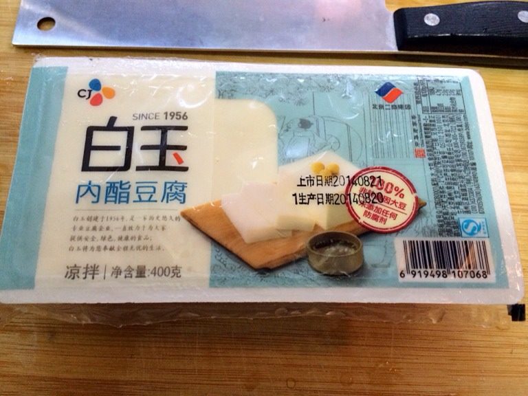 凉拌白玉豆腐,用水果刀划开盒上塑料膜