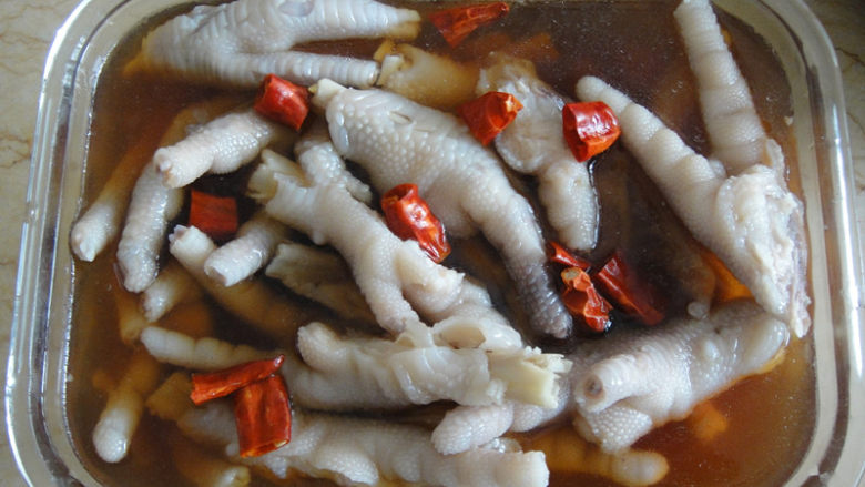 糟鸡爪,放入保鲜盒里倒入糟卤,糟卤能浸没食物为佳喜欢有点辣味,用三个干辣椒洗净后剪开加入盖上进冰箱冷藏4小时以上即可食用
