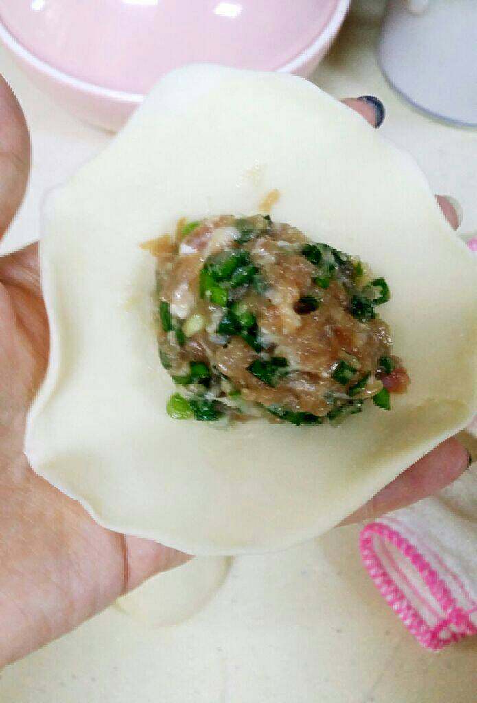 引人流口水的猪肉馅饼,取一份面团擀开,包入馅料,像包包子一样。