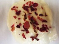 玫瑰奶油薄脆,用勺子舀面糊到铺了烤盘纸的烤盘上,抹面糊成圆形,撒上玫瑰花瓣
